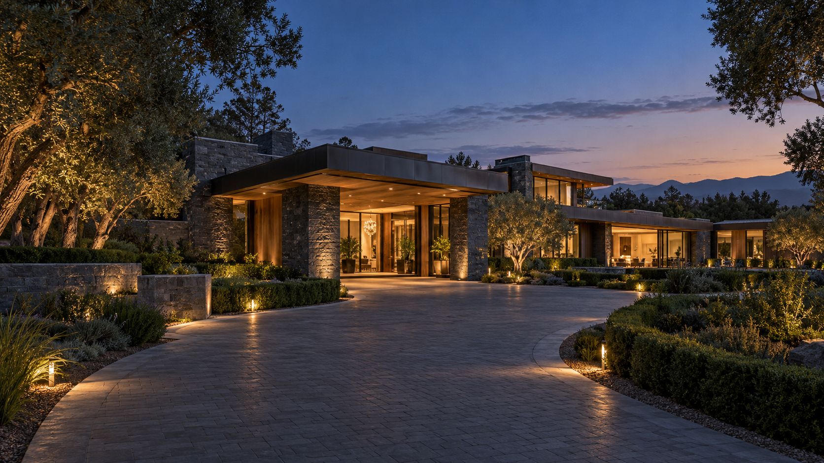 Stone motor court entry to a private estate at twilight